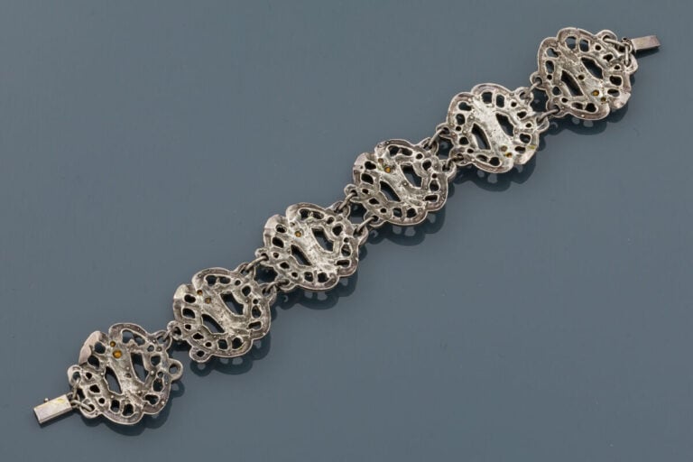 BRACELET en argent (850‰) ajouré à motifs de volutes enchevêtrées, ornés de str…