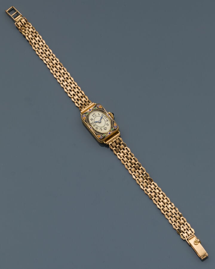 BRACELET MONTRE rectangulaire de dame en or jaune (750‰). Lunette ornée d'émail…