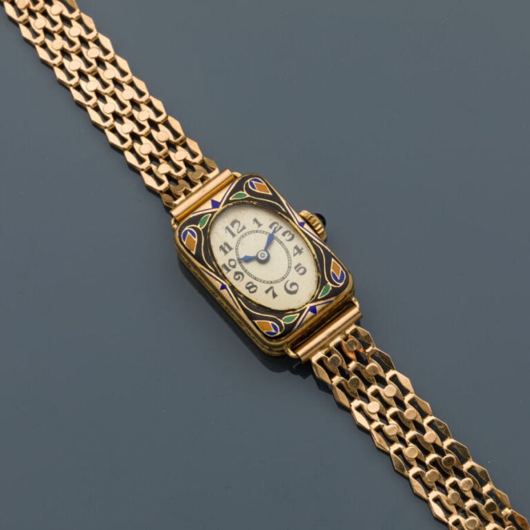 BRACELET MONTRE rectangulaire de dame en or jaune (750‰). Lunette ornée d'émail…