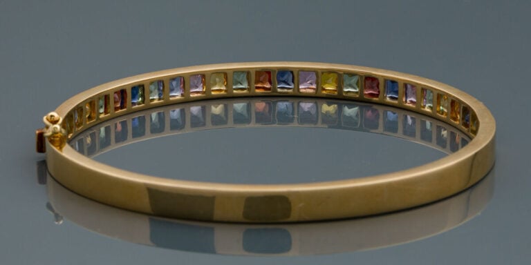 BRACELET "rainbow" rigide ouvrant en or jaune (750‰) serti d'un alignement de s…