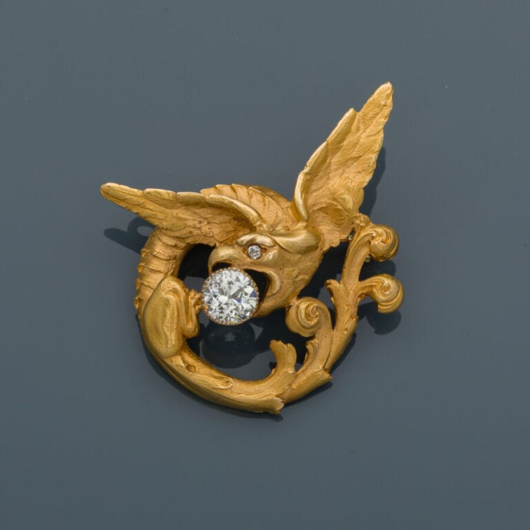 BROCHE anciennement PENDENTIF "chimère et volute" en or jaune (750‰) ajouré, fi…