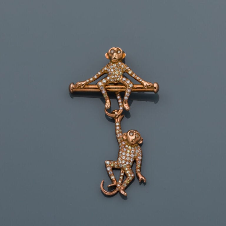 BROCHE "deux singes" en or rose (750‰) articulé, serti de diamants taille brill…