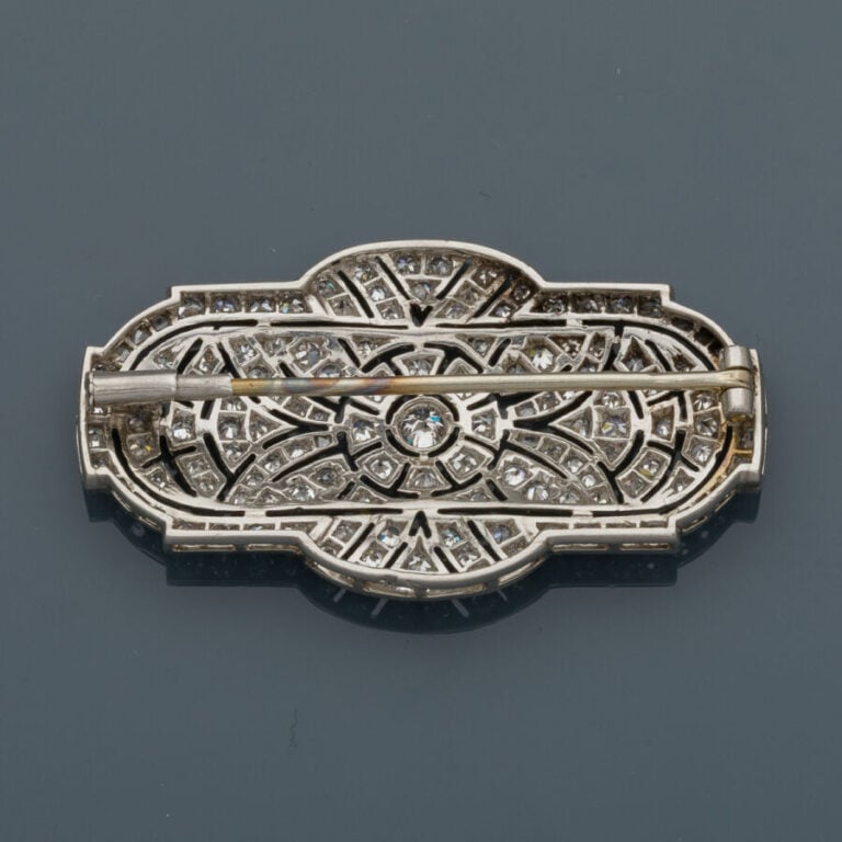 BROCHE en or gris (750‰) et platine (950‰) finement ajouré serti de diamants ta…