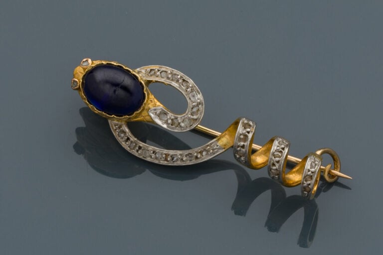 BROCHE "serpent" en platine (min. 850‰) et or jaune (750‰), la tête ornée d'un…