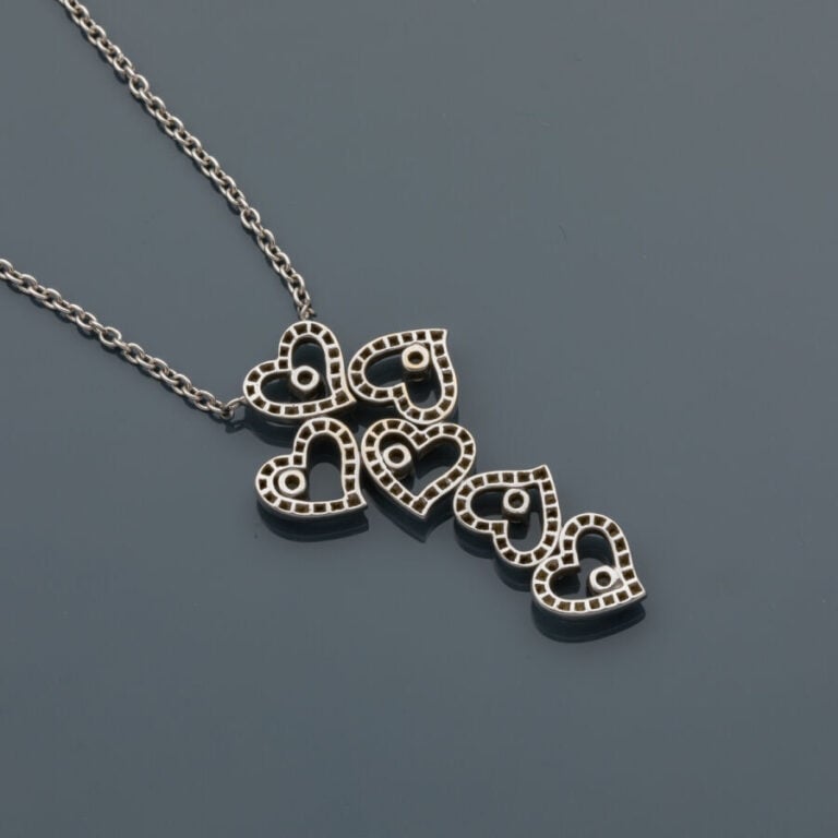COLLIER "cinq coeurs" en or gris (750‰) composé d'une chaînette retenant un mot…