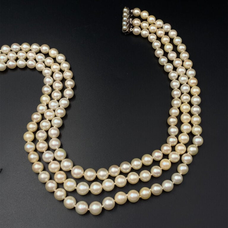 COLLIER composé de trois rangs de perles de culture blanches en chute. Fermoir…