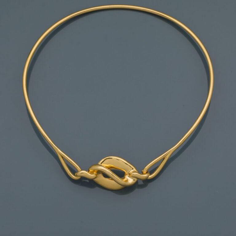COLLIER "torque" en or jaune (750‰) centré d'un motif "volutes" ajouré. - Trava…
