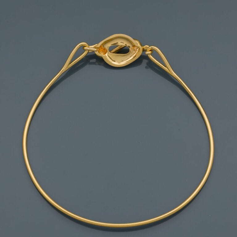 COLLIER "torque" en or jaune (750‰) centré d'un motif "volutes" ajouré. - Trava…