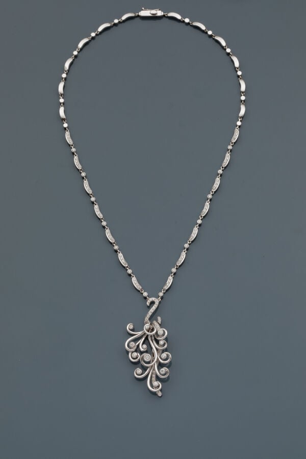 COLLIER "volutes" en or gris (750‰) serti de diamants taille brillant, retenant…