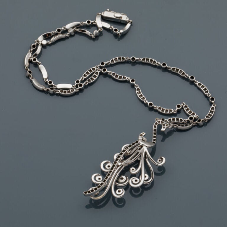 COLLIER "volutes" en or gris (750‰) serti de diamants taille brillant, retenant…
