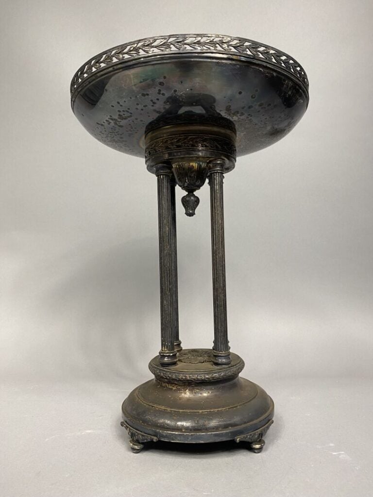 Coupe en métal argenté reposant sur une base quadripode composée de colonnes ca…