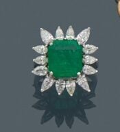 Importante BAGUE "marguerite" en or gris (750‰) serti d'une émeraude taillée à…
