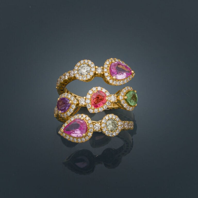 Large BAGUE légèrement souple en or jaune (750‰) serti de saphirs multicolores…