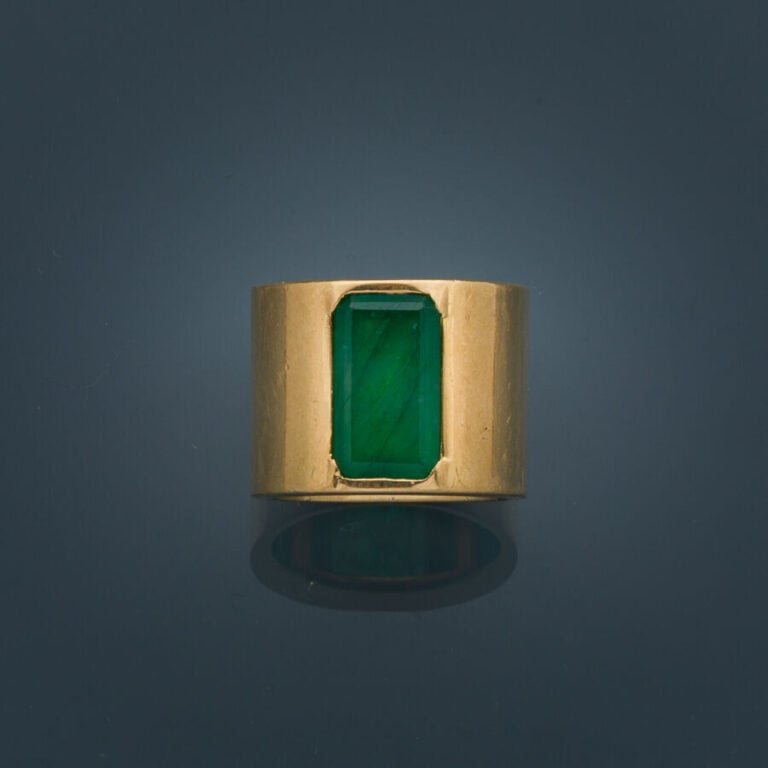 Large BAGUE plate en or jaune (750‰) serti d'une émeraude taillée à degrés (égr…