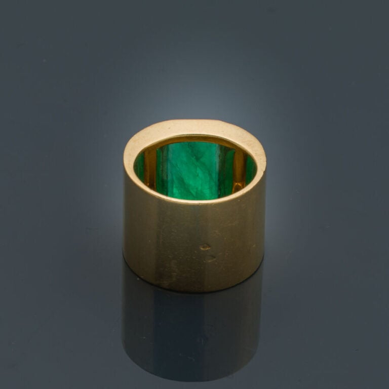 Large BAGUE plate en or jaune (750‰) serti d'une émeraude taillée à degrés (égr…