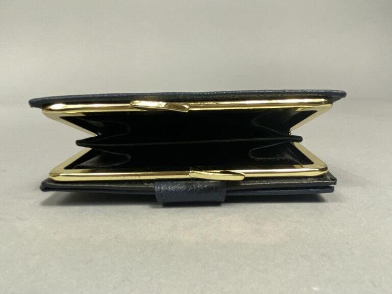 Lot comprenant un porte monnaie en cuir grainé bleu marine et un porte feuille…