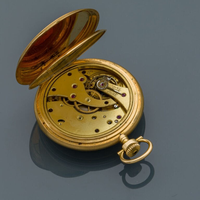 MONTRE de POCHE en or jaune (750‰) guilloché, carrure godronnée. Cadran émail b…