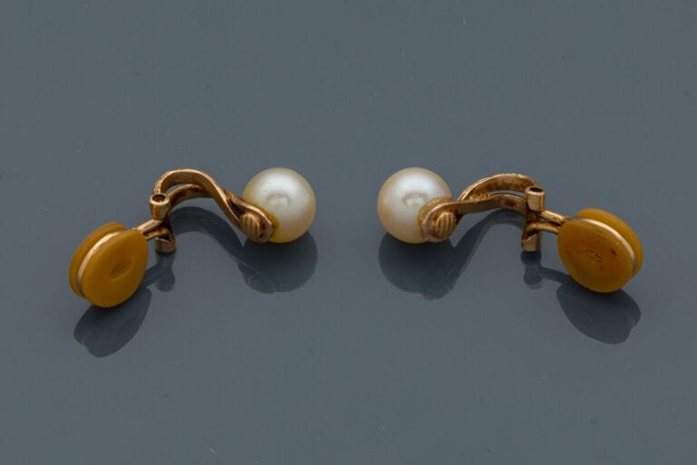 Paire de CLIPS d'OREILLES en or jaune (750‰) ciselé, orné chacun d'une perle de…