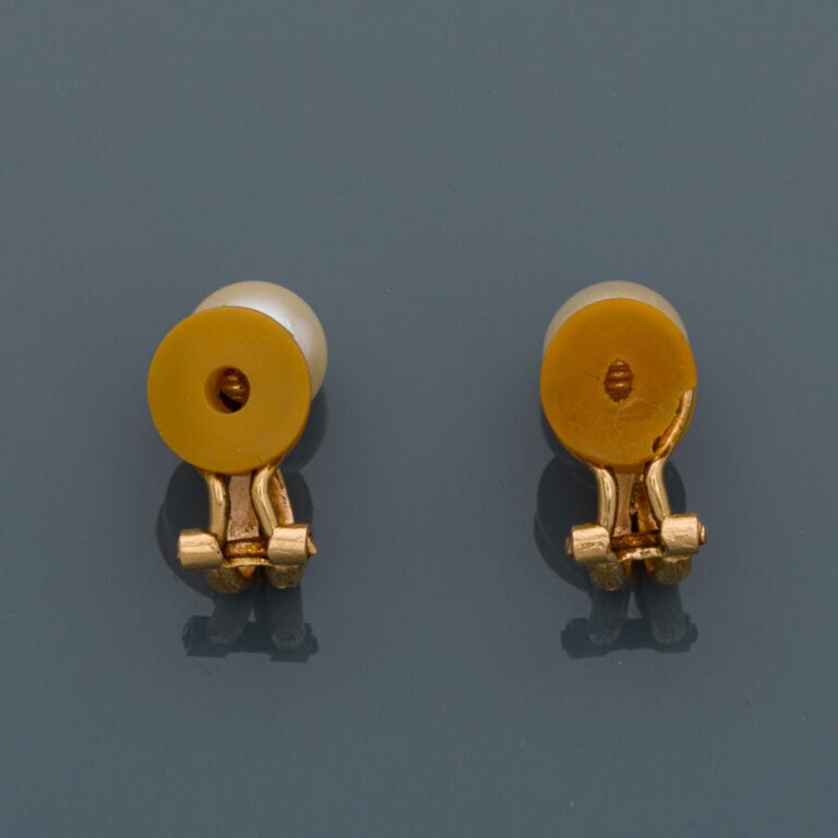 Paire de CLIPS d'OREILLES en or jaune (750‰) ciselé, orné chacun d'une perle de…