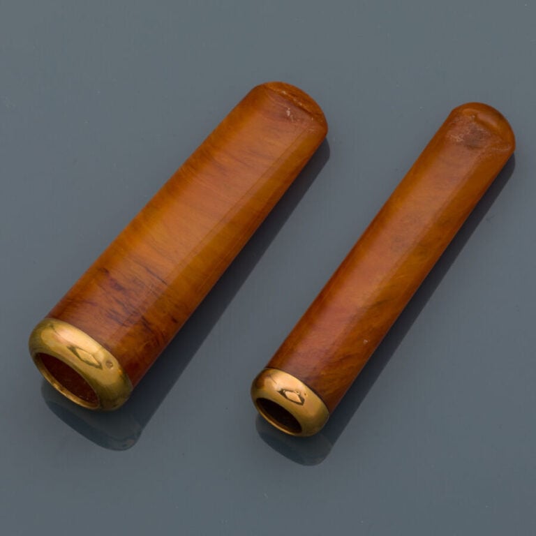 Paire de FUME-CIGARETTE en résine orange, bagues en or jaune (750‰). - Travail…