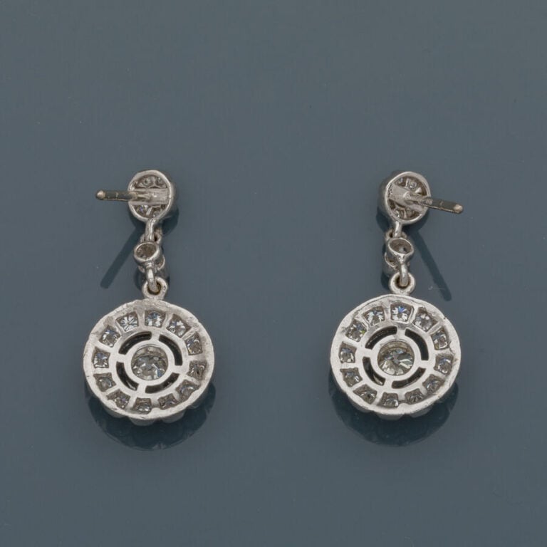 Paire de PENDANTS d'OREILLES "fleurs" en or gris (750‰) ajouré, serti de diaman…