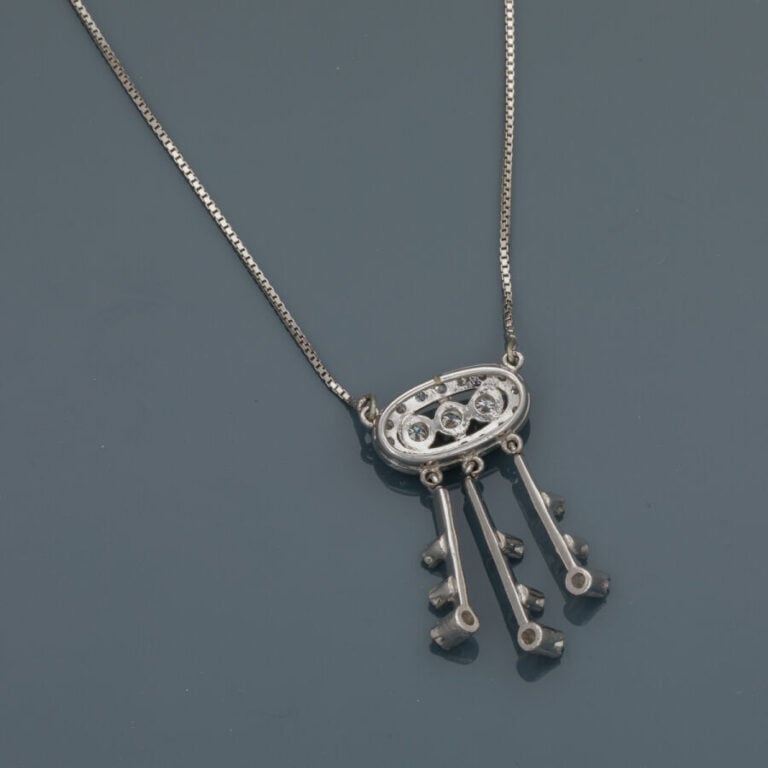 PENDENTIF et sa chaînette en or gris (750‰). Motif central ovale ajouré serti d…