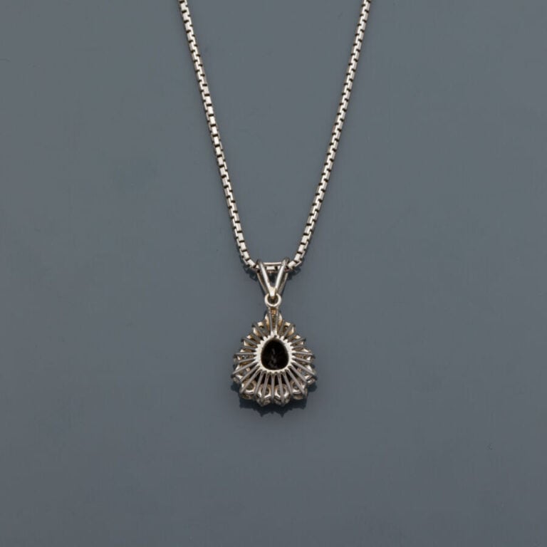 PENDENTIF "goutte" et sa chaînette en or gris (750‰) serti d'un saphir foncé ta…
