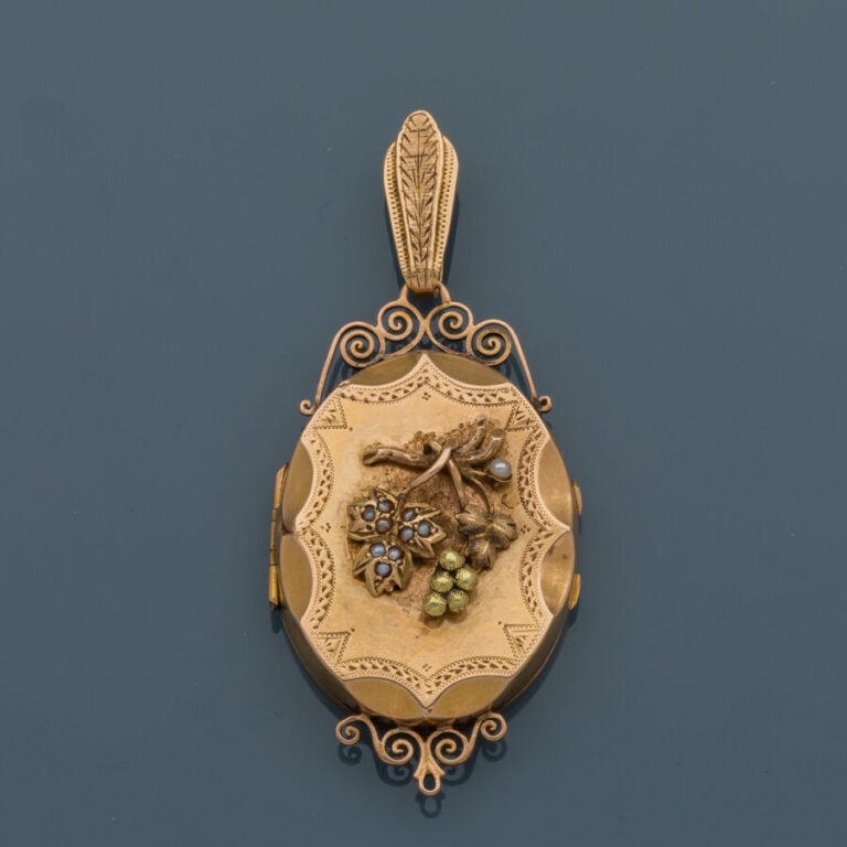 PENDENTIF "porte-souvenir" en or jaune (750‰) ajouré, ciselé et flanqué d'un mo…