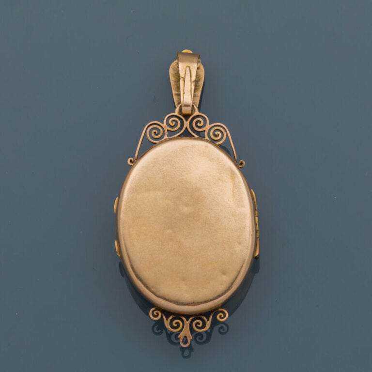 PENDENTIF "porte-souvenir" en or jaune (750‰) ajouré, ciselé et flanqué d'un mo…