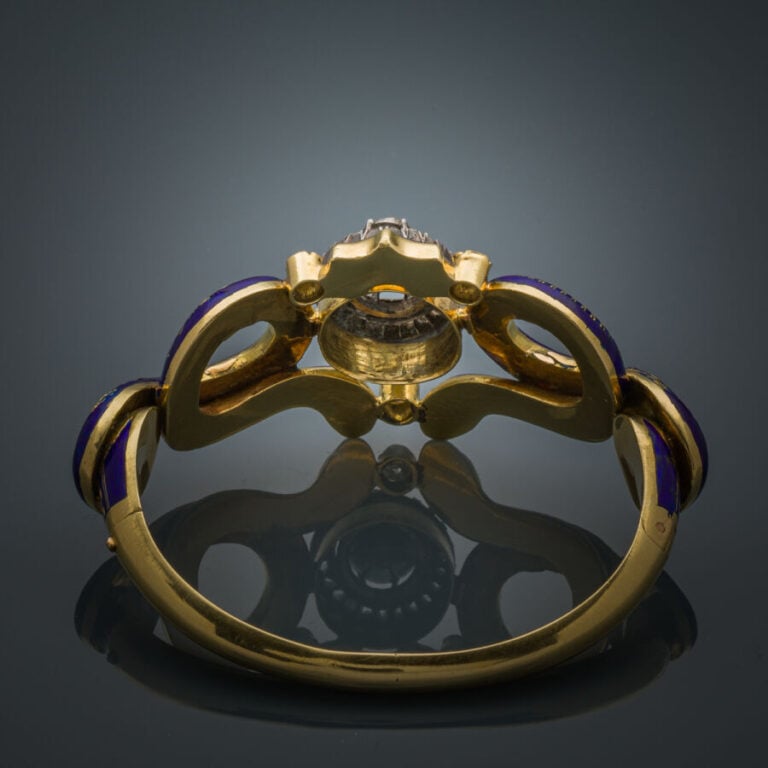 Rare BRACELET "serpents" rigide ouvrant en or jaune (750‰) ajouré, orné d'émail…