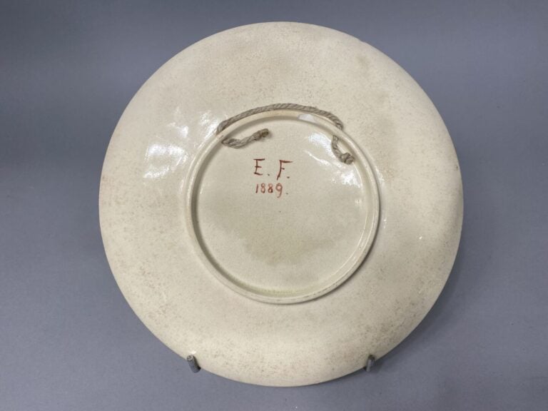 Assiette en faïence craquelée polychrome à décor de rinceaux et médaillon au po…