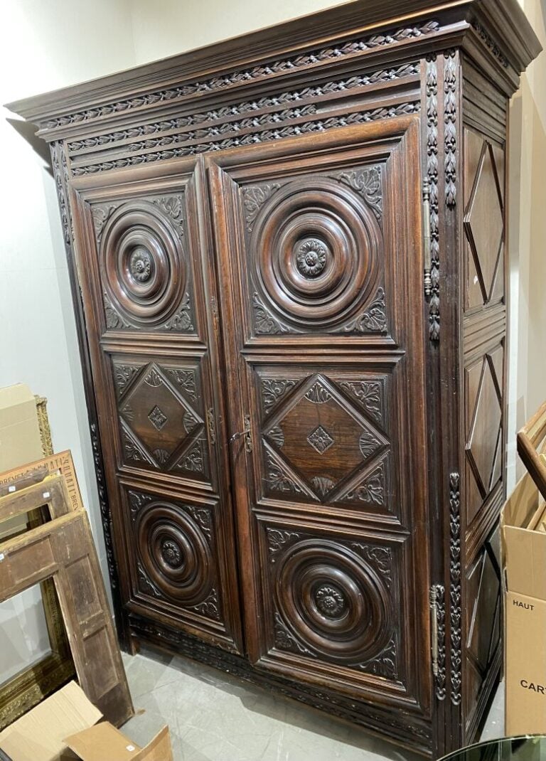 Armoire XVIIe en bois mouluré et sculpté ouvrant par deux portes à décor de los…