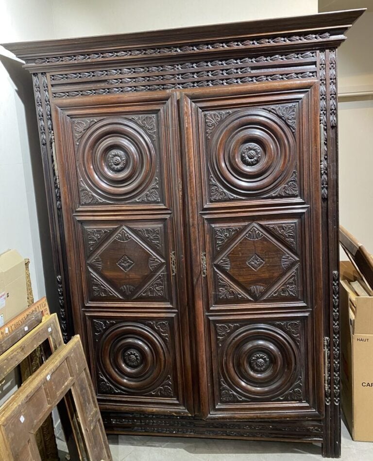 Armoire XVIIe en bois mouluré et sculpté ouvrant par deux portes à décor de los…