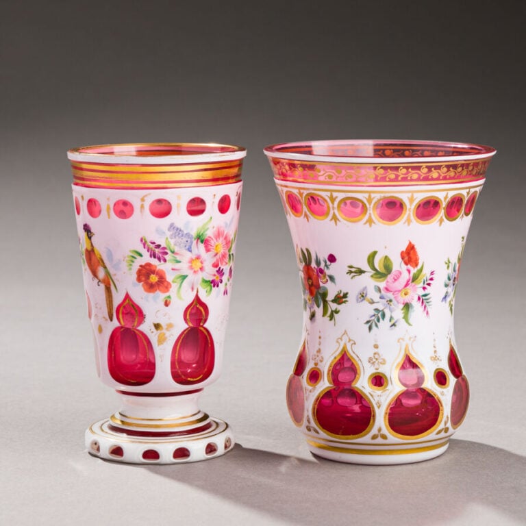 Bohême.Deux gobelets. - 1°/ Gobelet à pièdouche en verre rose doublé d'émail bl…