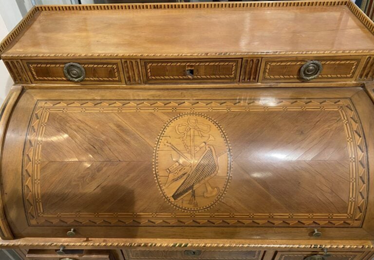 Bureau à cylindre à décor marqueté d'attributs. Le cylindre démasque trois tiro…