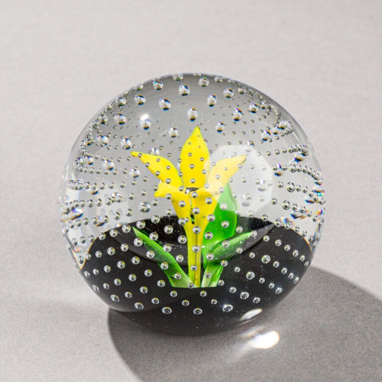 Caithness. Presse-papiers « Flower in the rain » orné d'une fleur jaune dressée…