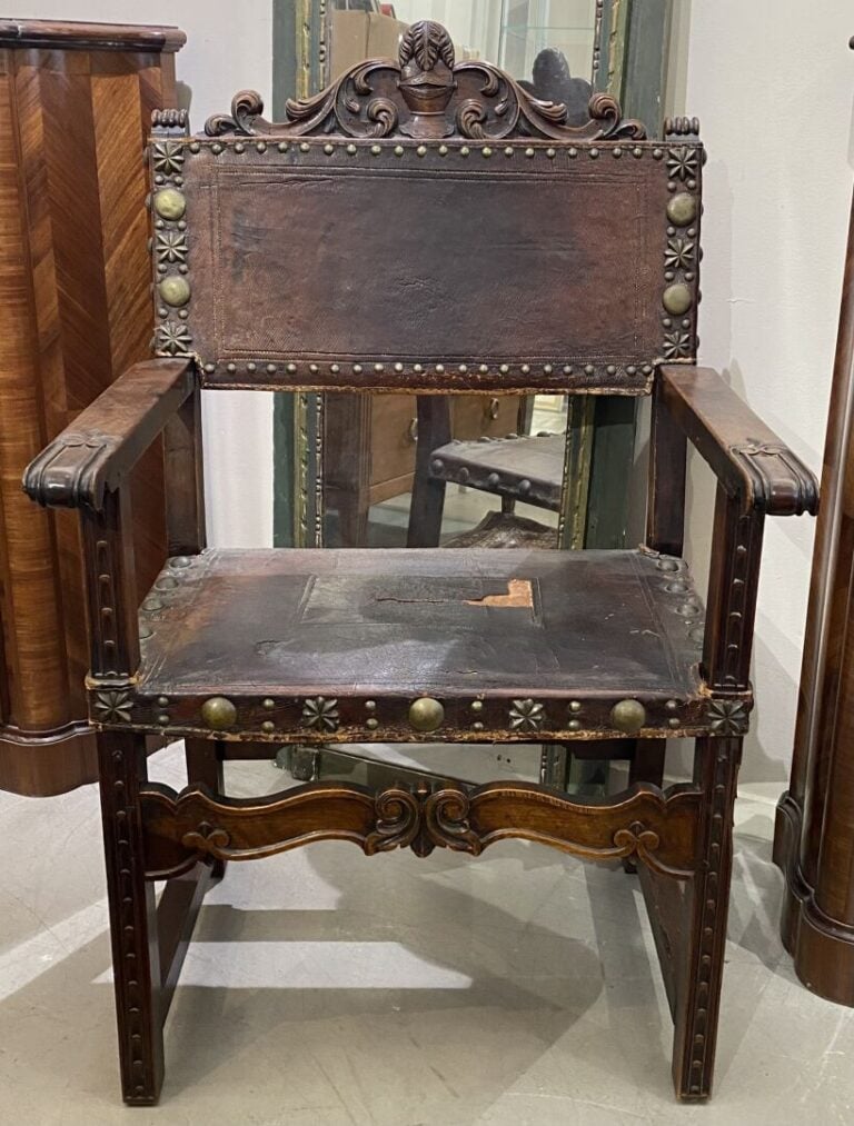 Fauteuil à bras en bois à décor sculpté de heaume et feuillages, l'assise en cu…