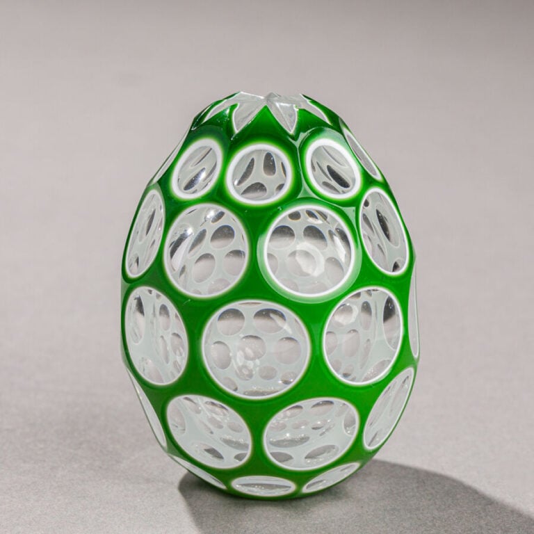 Saint-Louis. Oeuf en cristal overlay vert triplé sur émail blanc. Taille à cinq…