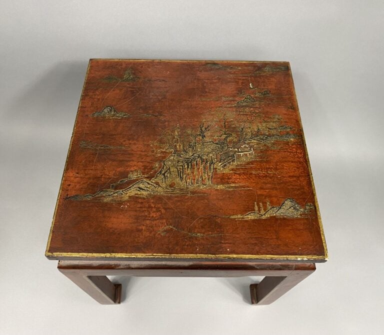Chine - Petite table basse en bois laqué rouge à décor doré d'un village entour…