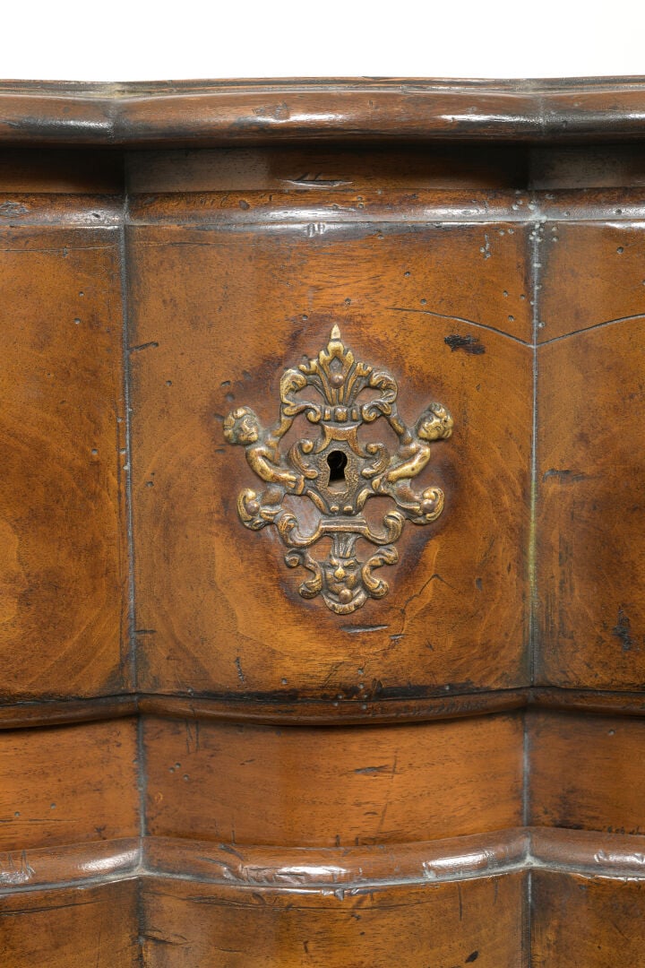 Commode en noyer mouluré à façade légèrement arbalète ouvrant à trois tiroirs s…