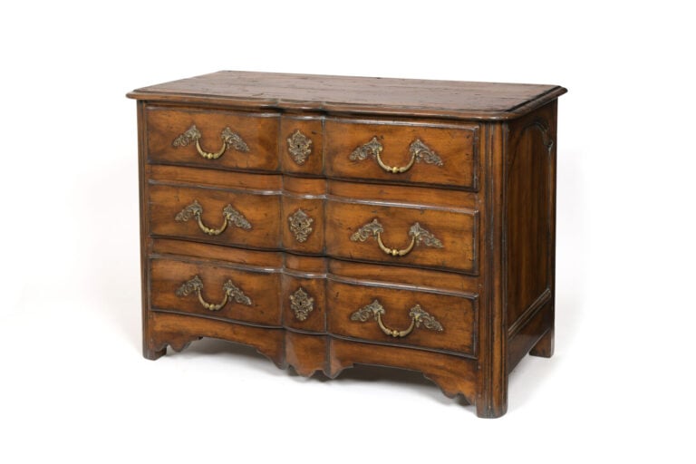 Commode en noyer mouluré à façade légèrement arbalète ouvrant à trois tiroirs s…