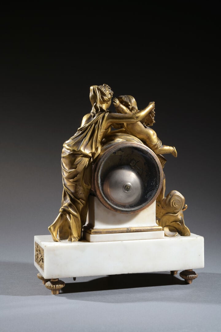 Pendule en bronze ciselé doré, figurant Vénus et l'Amour, et ses attributs. Cad…