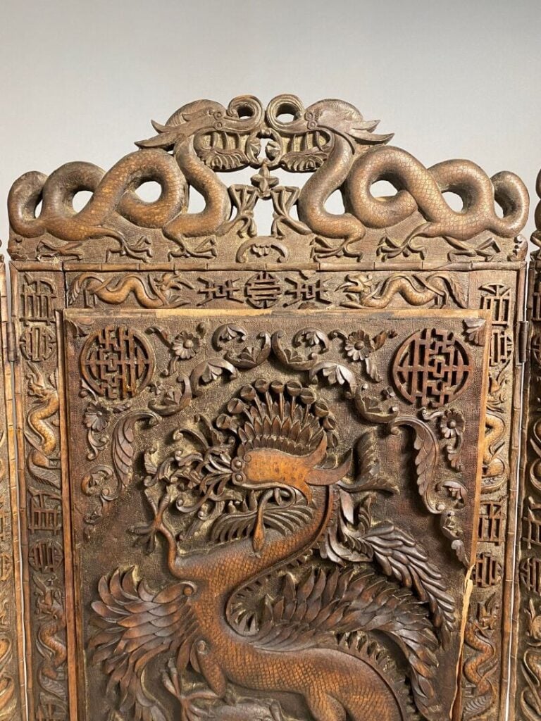 Vietnam - Important écran triptyque en bois richement sculpté de dragons, chauv…