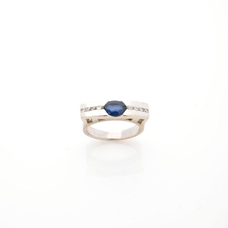 BAGUE "barrette" en or gris (750‰) centré d'un saphir de forme ovale, épaulé d'…