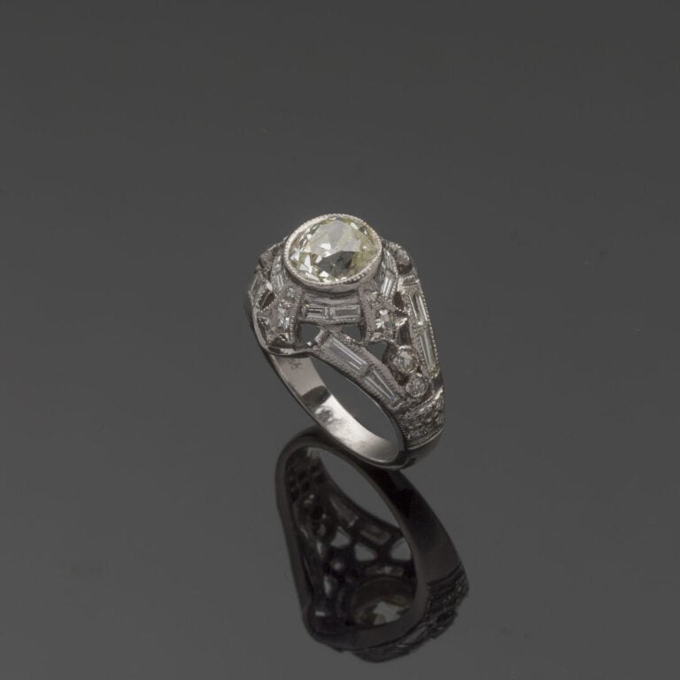 BAGUE "dôme" en or gris (750‰) ajouré et ciselé, serti d'un diamant taille anci…
