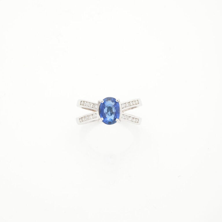 BAGUE en or gris (750‰) ajouré, serti d'un saphir ovale pesant 2,34 cts, épaulé…