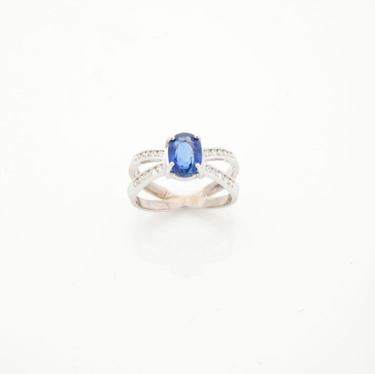 BAGUE en or gris (750‰) ajouré, serti d'un saphir ovale pesant 2,34 cts, épaulé…