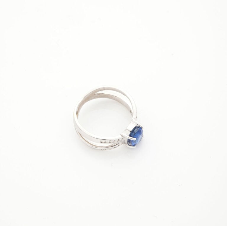 BAGUE en or gris (750‰) ajouré, serti d'un saphir ovale pesant 2,34 cts, épaulé…