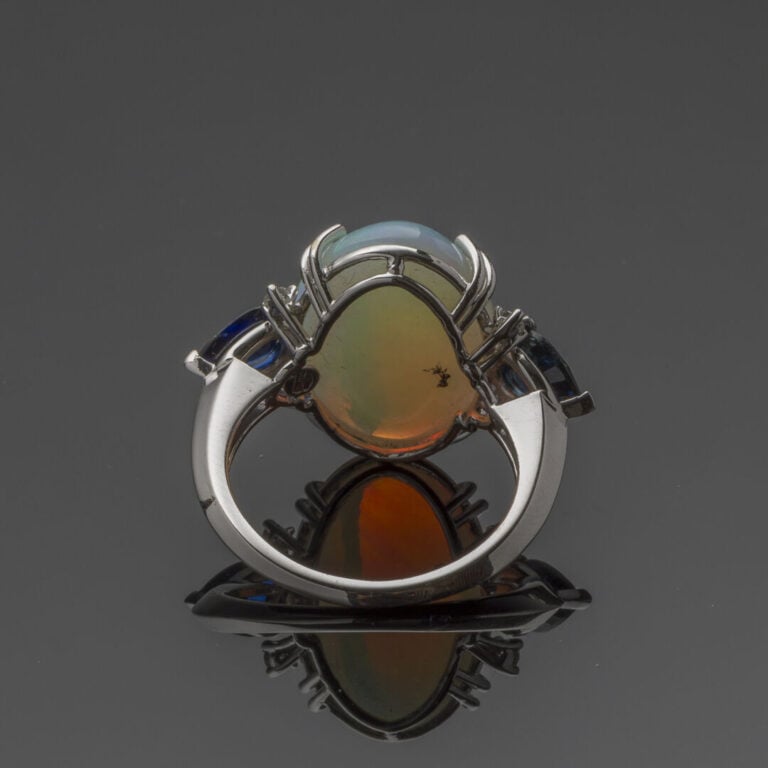 BAGUE en or gris (750‰) orné d'une opale cabochon épaulée de chaque côté d'un s…