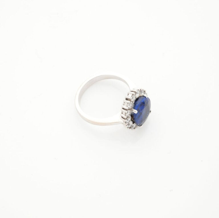 BAGUE en or gris (750‰) serti d'un saphir pesant 4,95 cts, dans un entourage de…